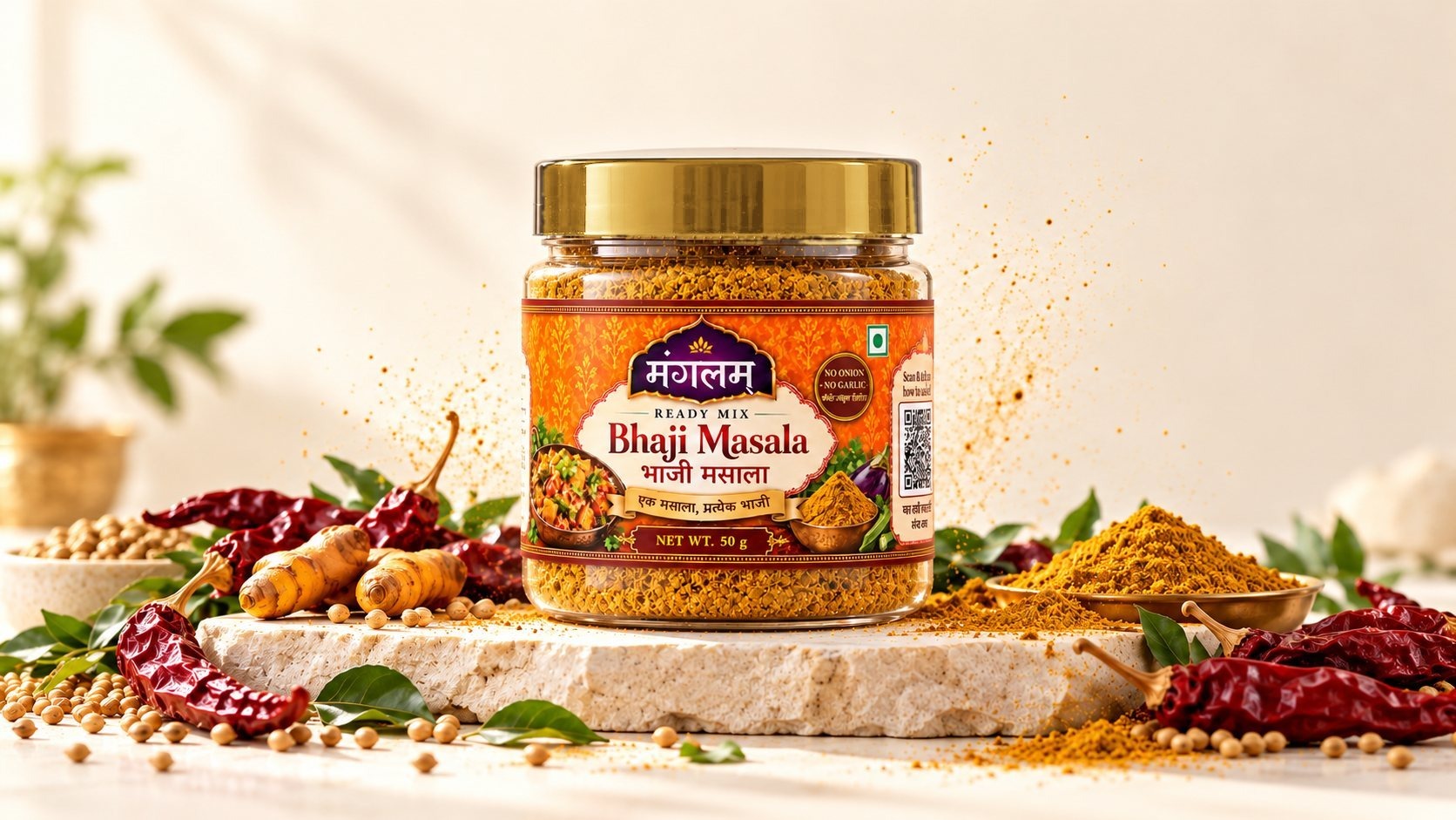 Mangalam Bhaji Masala Trial Pack jar on a pale limestone slab among dried Kolhapuri chillies, turmeric and coriander seeds